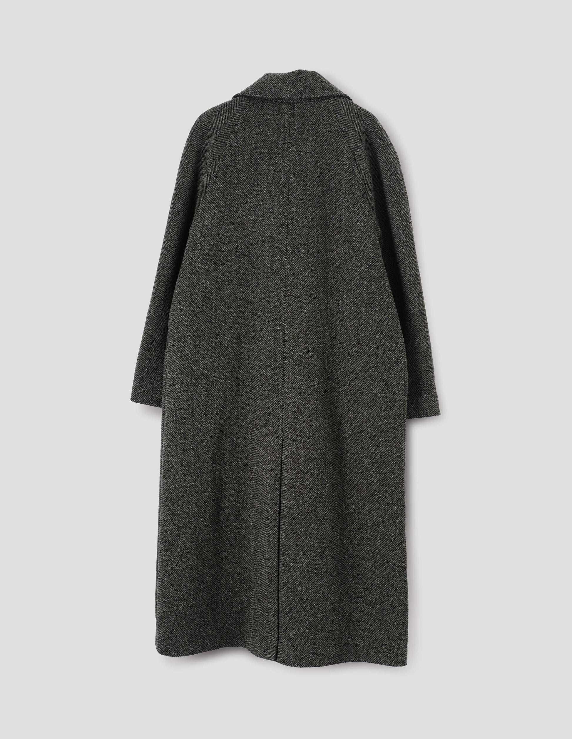 Green and black herringbone wool longline overcoat with raglan sleeve and back centre vent. Back flat lay view.