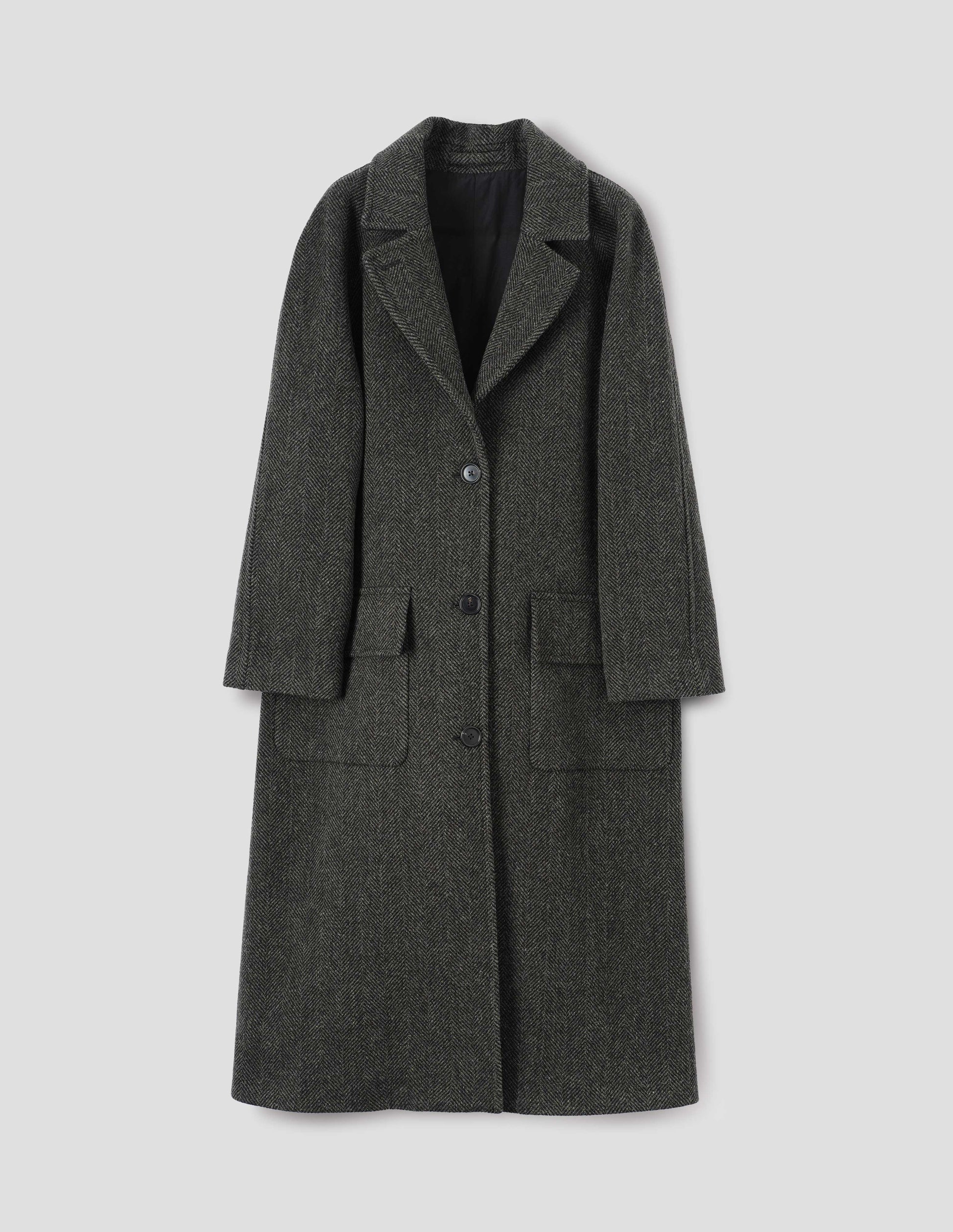 Green and black herringbone wool longline overcoat with raglan sleeve, button fastening lapel and deep flap patch pockets. Front flat lay view.