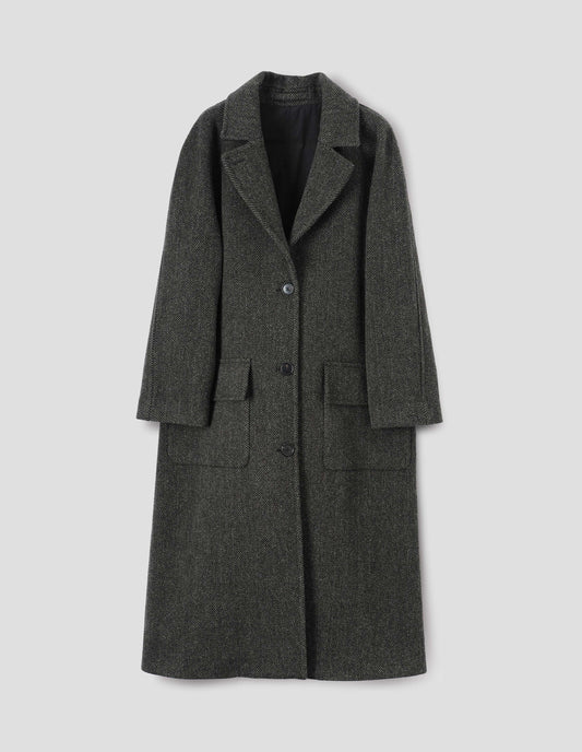 Green and black herringbone wool longline overcoat with raglan sleeve, button fastening lapel and deep flap patch pockets. Front flat lay view.