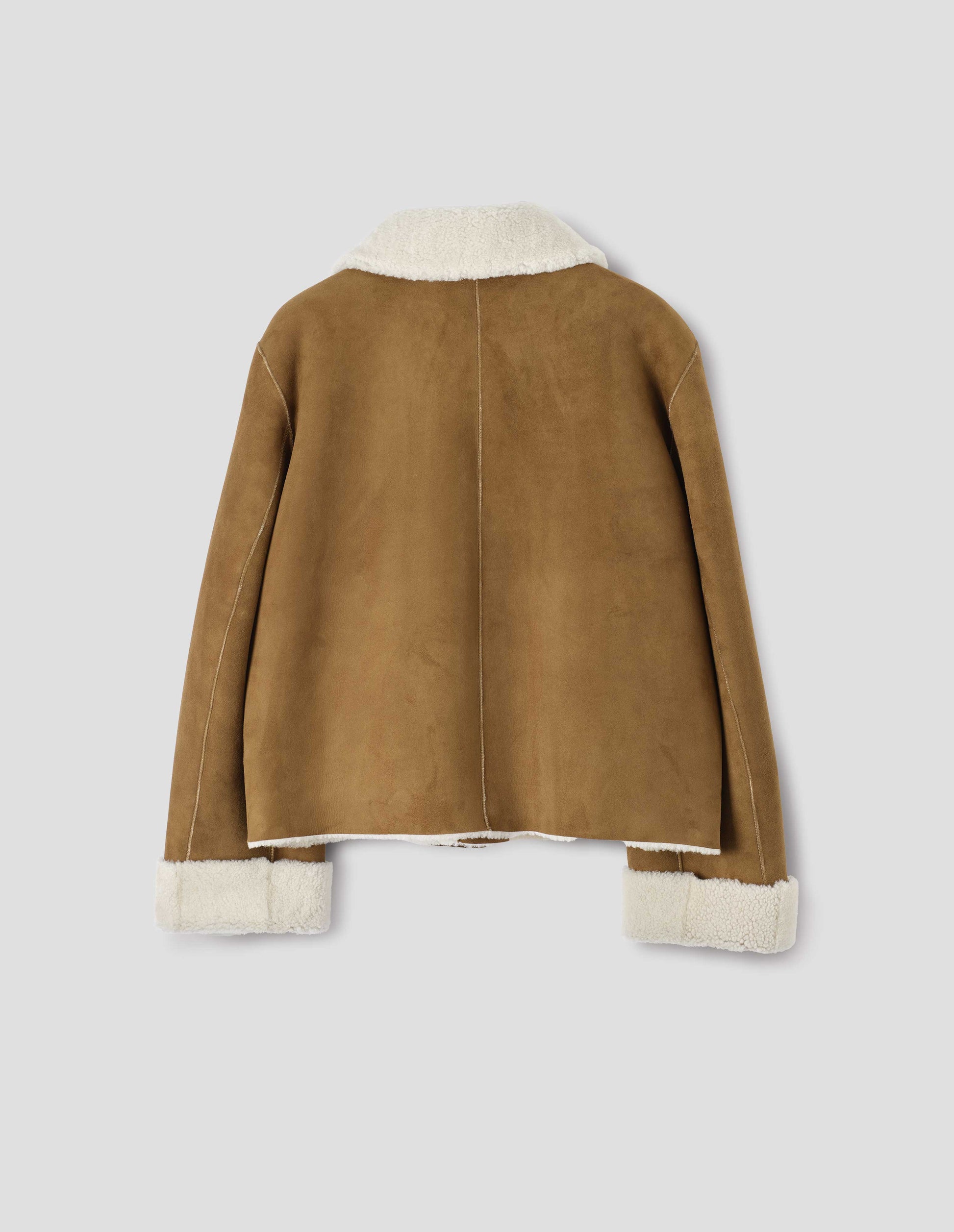 Tan and ecru shearling cropped jacket, with turn back cuffs, side welt pockets and raw edge finishing on seams. Back flat lay view.