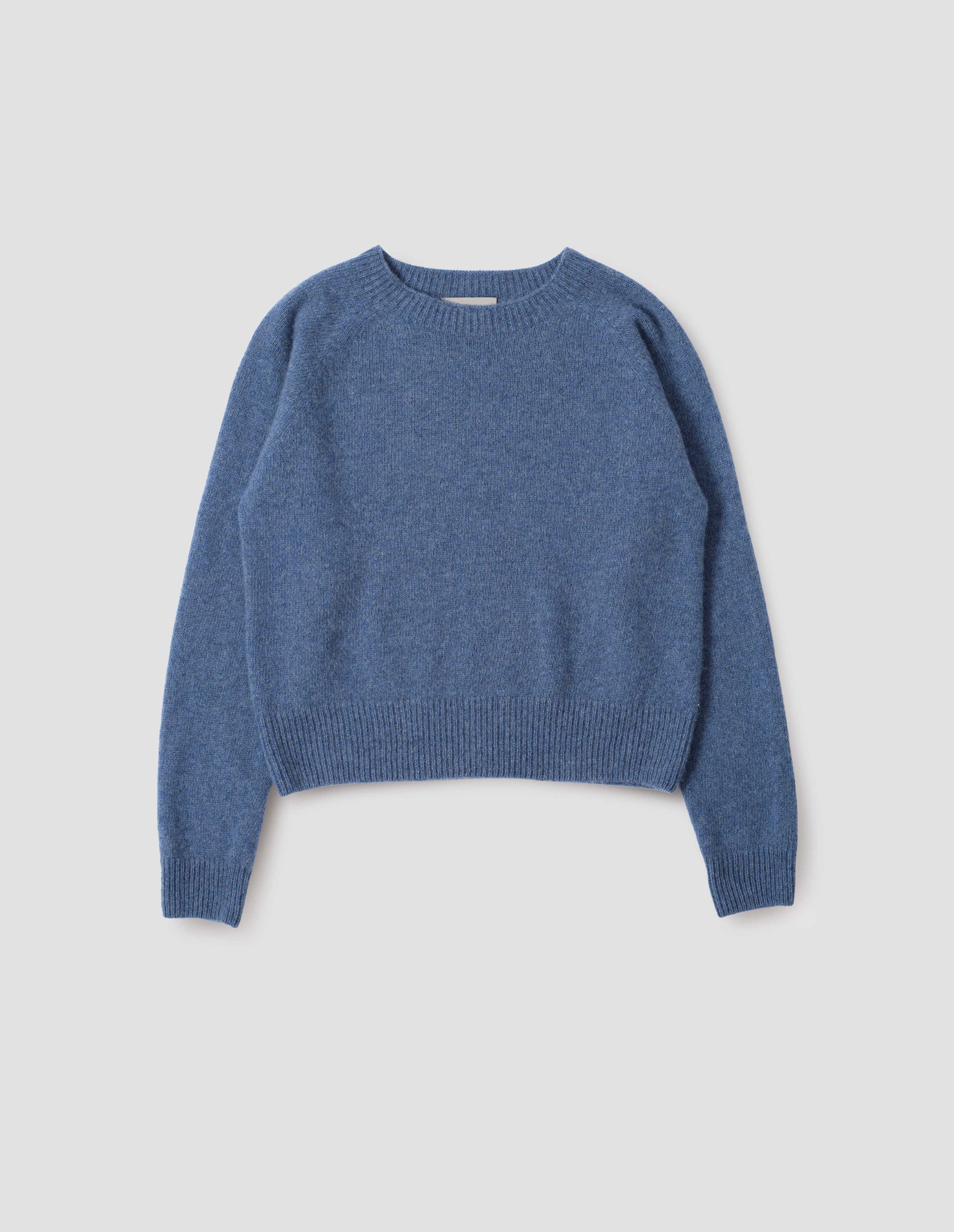 Blue long sleeve cashmere jumper, with raglan sleeve and contrasting rib on neck, cuffs and hem. Front flat lay view.