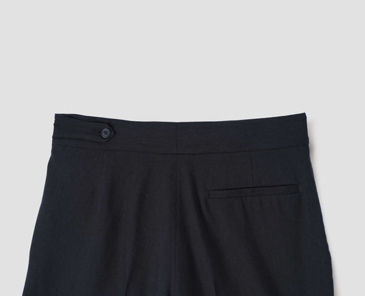 Black lightweight trousers with pull through double tab side fastening and back pocket, back flat lay view.