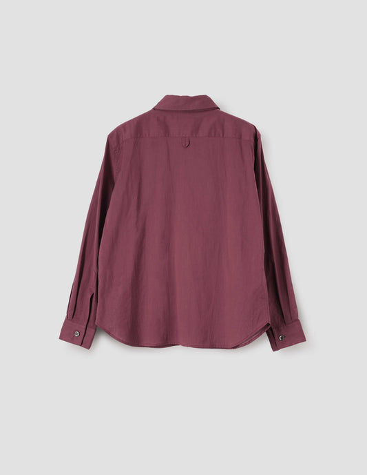 Dark red shirt with mother of pearl buttons on cuffs and hanger loop detail on back yoke, back flat lay view.