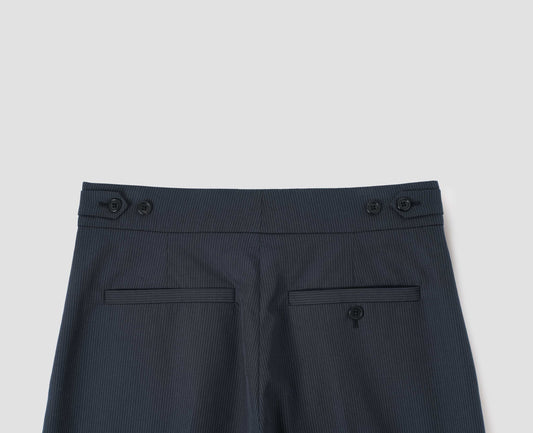 Dark blue trousers with grey stripes, horn button side adjusters, welt back pocket and button through welt back pocket, back flat lay view.
