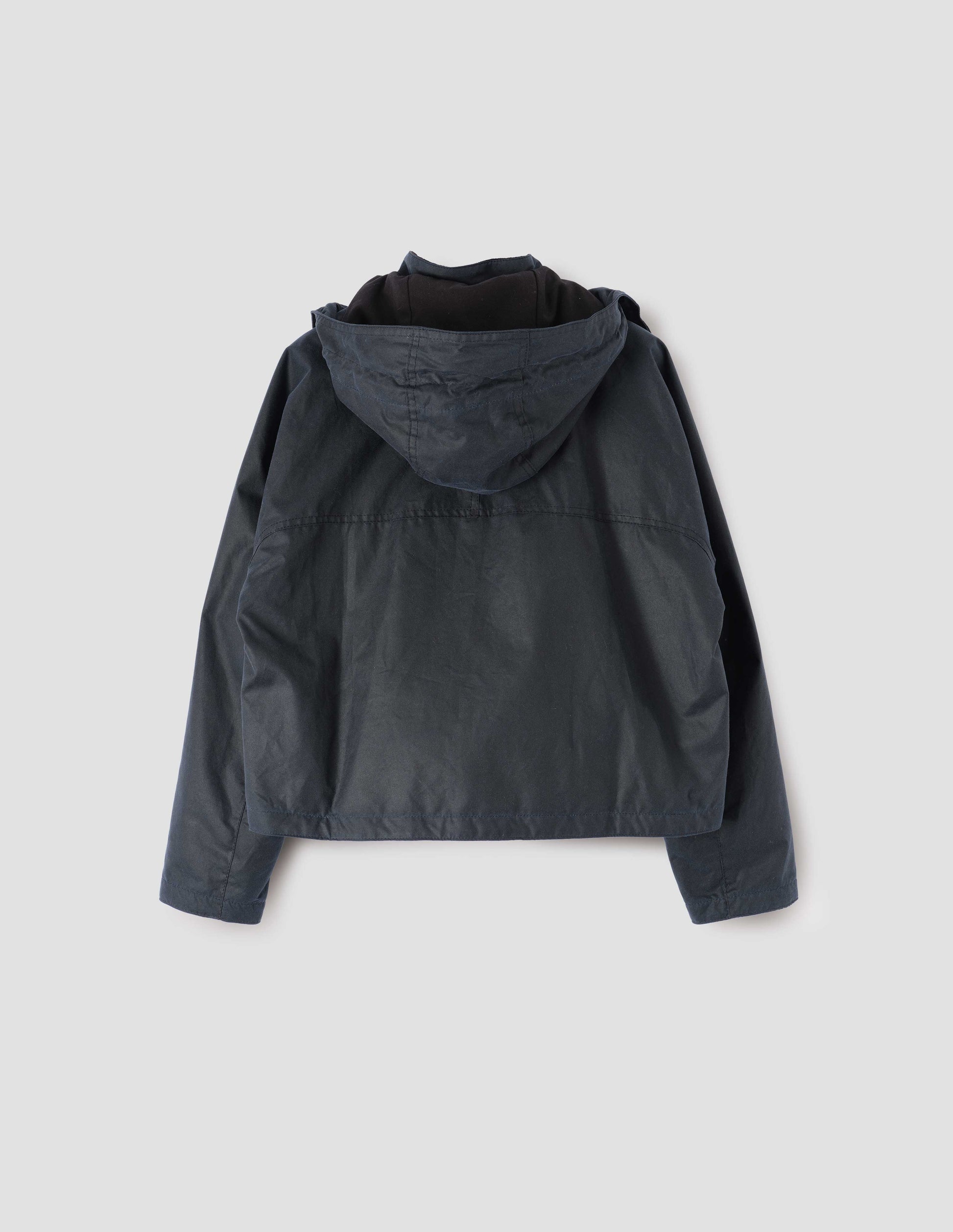 Dark blue boxy jacket with stand collar, hood and raglan sleeve. Back flat lay view.