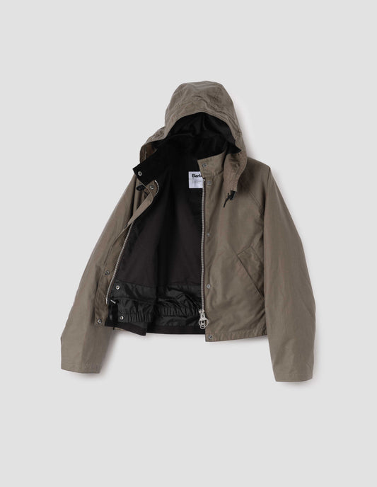 Dark beige cotton drill lined boxy jacket with stand collar and hood with wire adjustable peak, raglan sleeve, two-way zip fastening, press stud storm flap, wide storm welt side pockets and elasticated snow skirt inside. Open flat lay view.