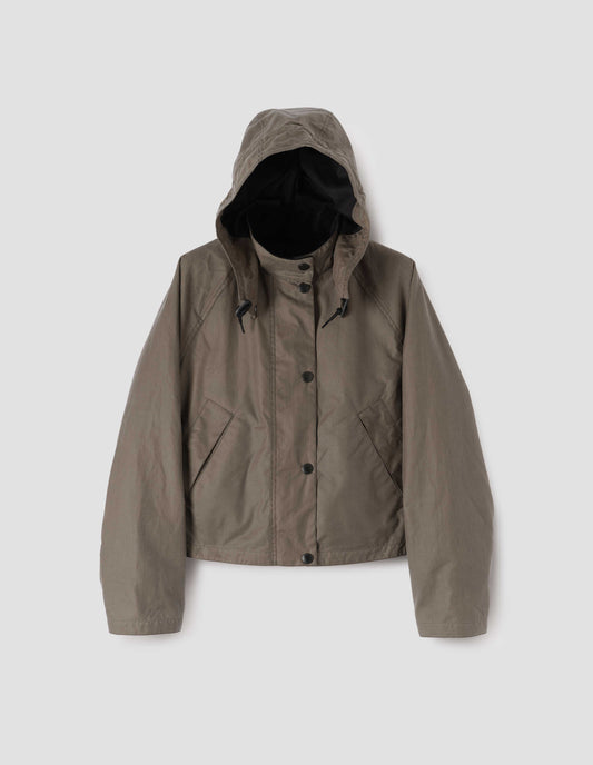 Dark beige cotton drill lined boxy jacket with stand collar and hood with wire adjustable peak, raglan sleeve, press stud storm flap and wide storm welt side pockets. Front flat lay view.
