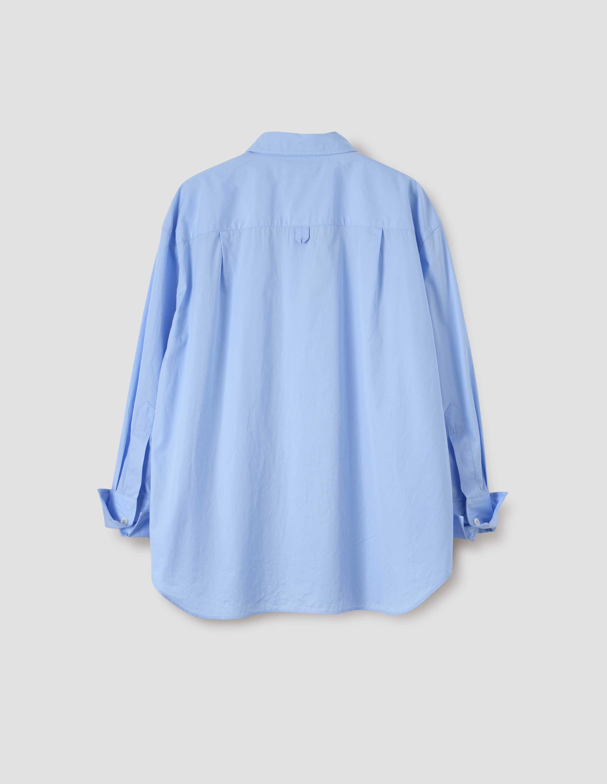 Light blue shirt with hanger loop detail on back yoke and turned up cuffs with mother of pearl buttons. Back flat lay view.