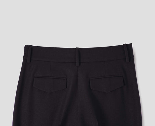 Black long leg wool trousers, with belt loops and concealed button fastening flap back pocket. Back flat lay view.