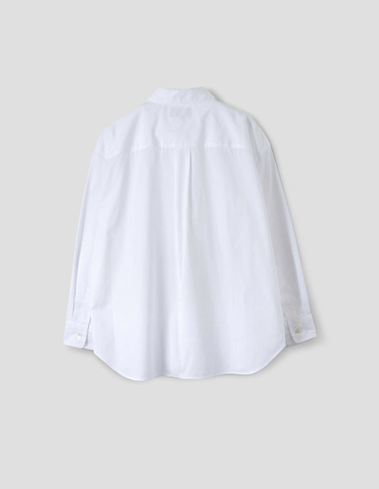 White cotton shirt with narrow shoulder yoke and back pleat, mother of pearl buttons on cuffs and curved hem. Back flat lay view. 