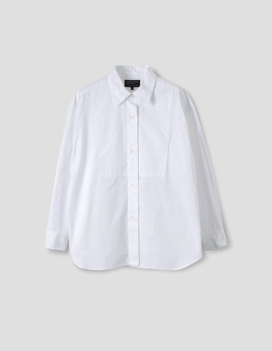 White cotton shirt with pointed stand collar, mother of pearl buttons on placket, double-layer bib front and curved hem. Front flat lay view.