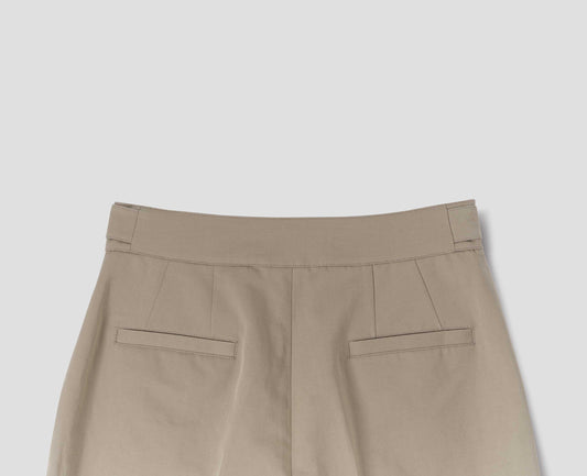 Beige cotton linen trousers with side cinches and welt back pockets. Back flat lay view.
