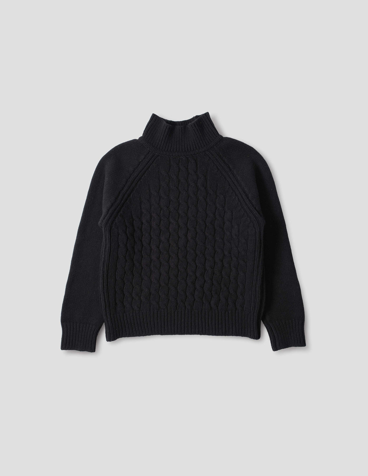 Black merino jumper with ribbed high neck collar, front cable design, raglan sleeves with ribbed side seams, cuffs and hem. Front flat lay view.
