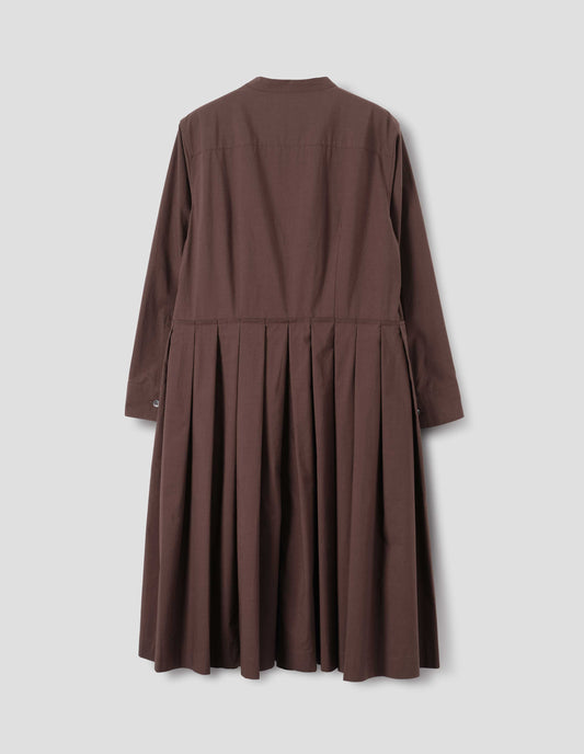 Brown collarless cotton dress with shirt yoke, long sleeves with mother of pearl buttons on cuffs and pleated skirt with concealed side pockets. Back flat lay view.