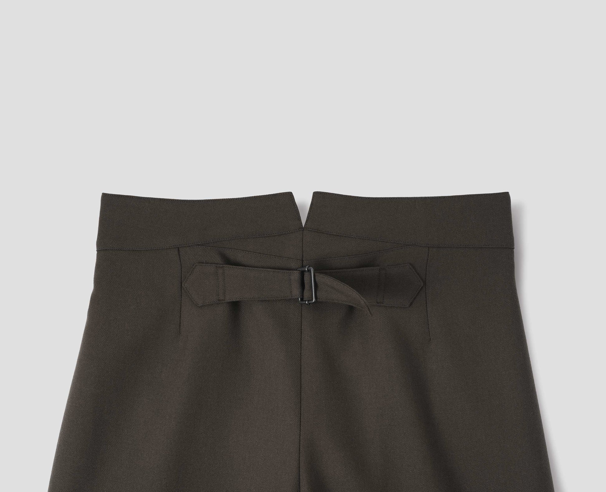 Brown wool trousers with back cinch. Back flat lay view.