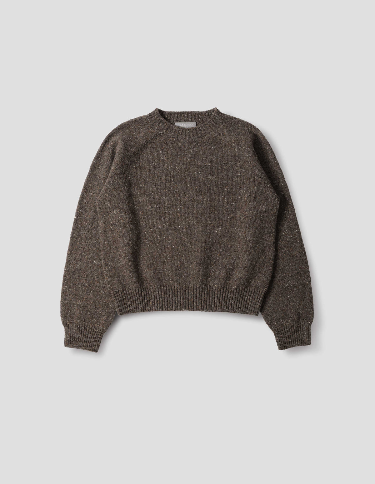 Brown crew neck wool jumper with fully fashioned bracelet length raglan sleeves, circular knitted body and wide rib detailing at neck, cuffs and hem. Front flat lay view.