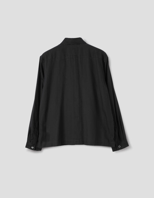 Black cotton cashmere sheer shirt with mother of pearl buttons on narrow cuffs with pleats and with square side split hem. Back flat lay view.