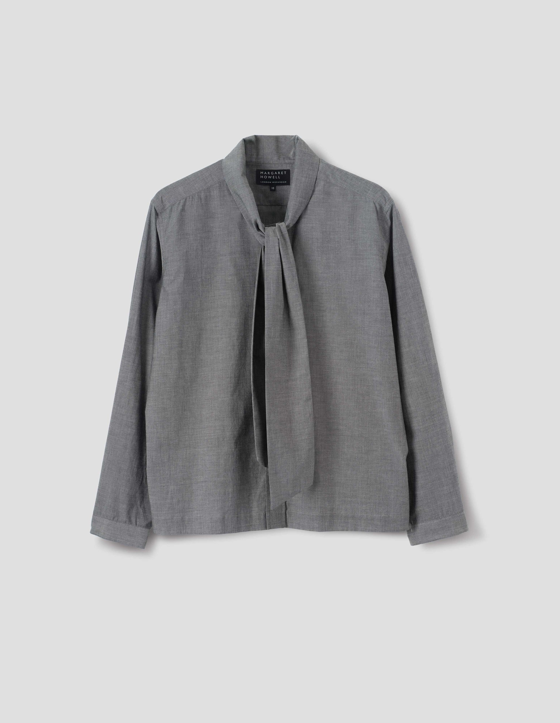 Grey cotton shirt with attached tie that can be worn tied or loose, lipped placket, narrow cuffs and with square side split hem. Front flat lay view. 