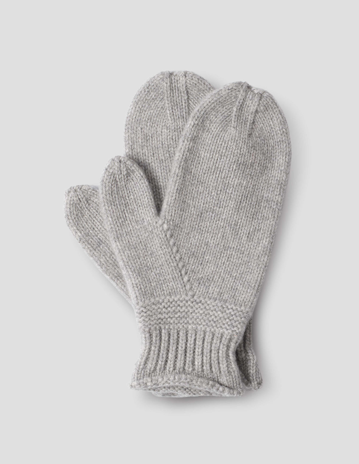 Grey merino cashmere knitted mittens with contrasting garter stitch band and rib cuffs. Front flat lay view.