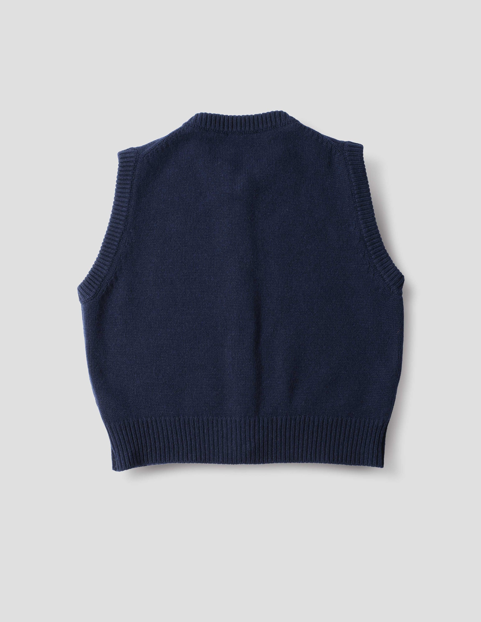 Dark blue cashmere merino knitted gilet with rib detailing at neck, armholes and hem. Back flat lay view.
