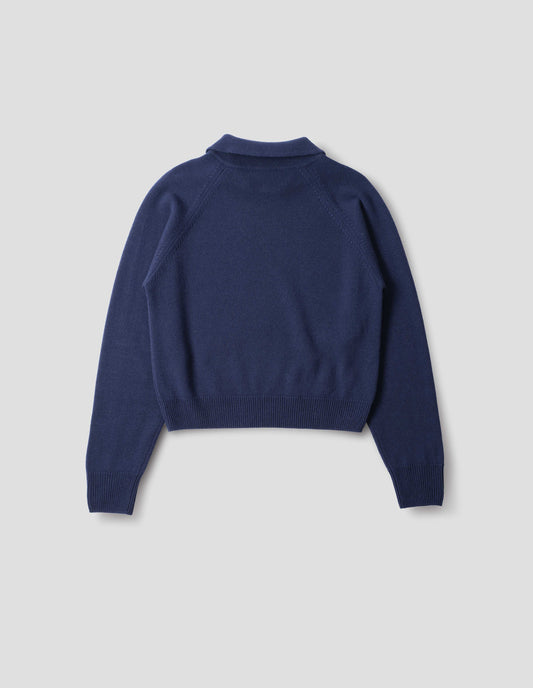 Dark blue merino jumper with collar, raglan sleeves, ribbed cuffs and hem. Back flat lay view.
