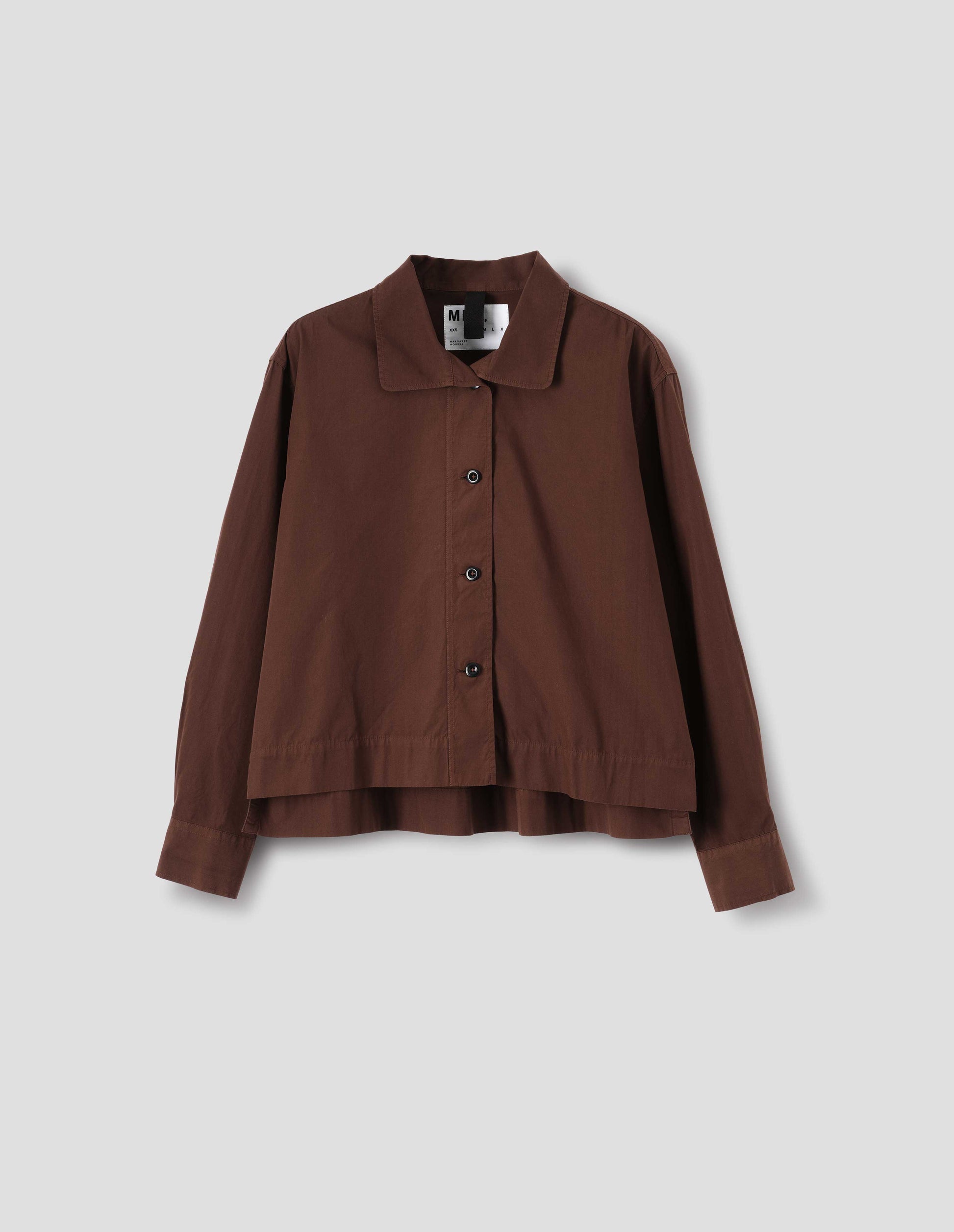 Brown cotton shirt, with  asymmetric collar and brown buttons, front flat lay view.