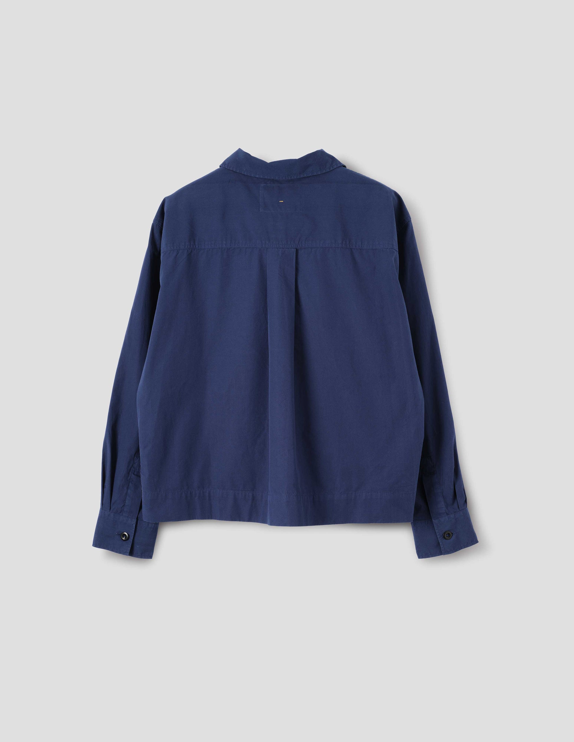 Blue cotton shirt, with box pleat on the back yoke and button cuffs, back flat lay view.