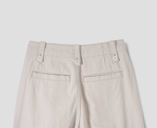 Off white trousers with grown-on waistband, button-fastening belt loops, and two back welt pockets. Back flat lay view.