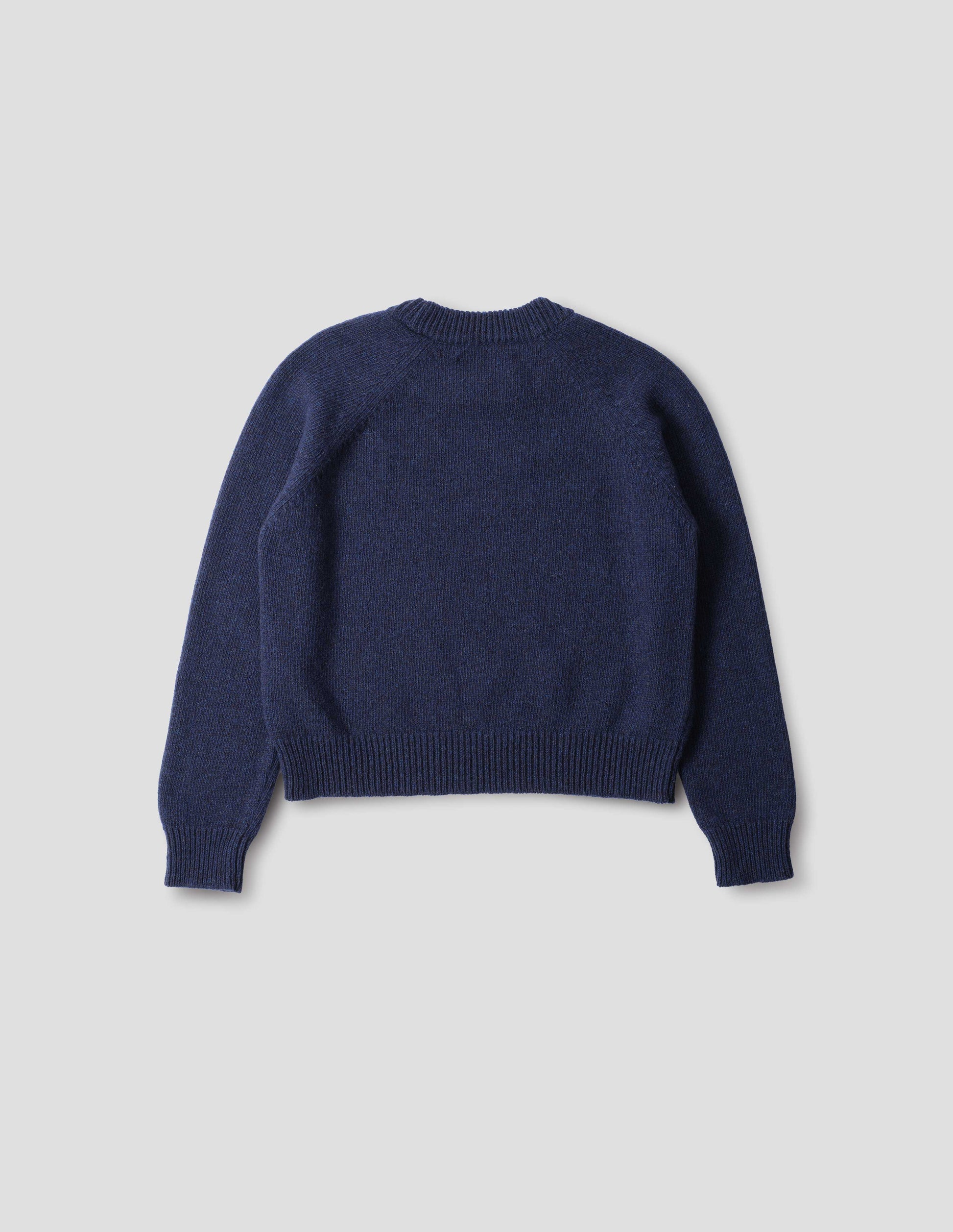 Blue lambswool jumper, with raglan sleeves, and ribbed neck, cuffs and hem, back flat lay view.