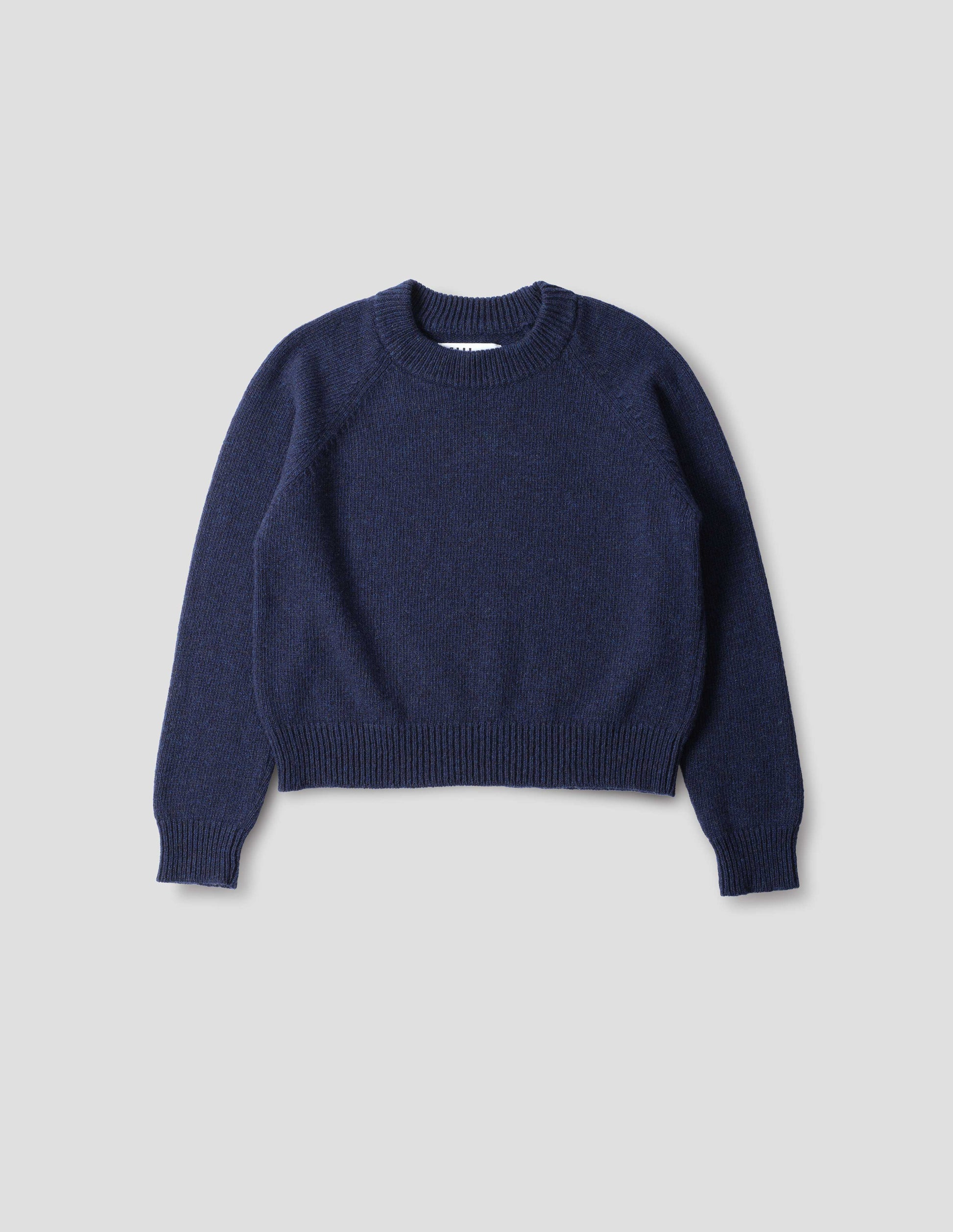 Blue lambswool jumper, with  crew neck, raglan sleeves, and ribbed neck, cuffs and hem, front flat lay view.