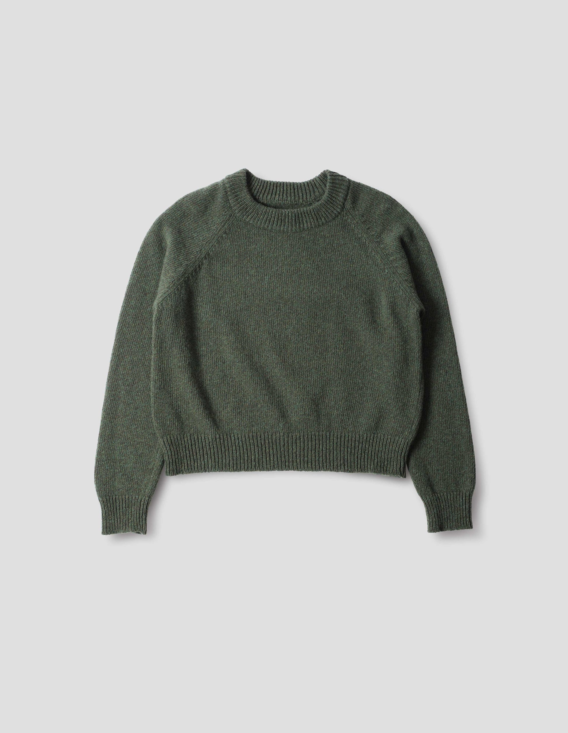 Green knitted wool jumper with crew neck, raglan sleeves, and rib detailing on the neck, cuffs and hem. Front flat lay view.