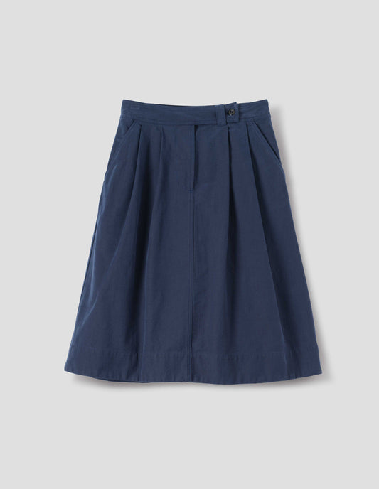 Dark blue cotton skirt, with loop and button fastening, slant pockets and ticket pocket, front flat lay view.