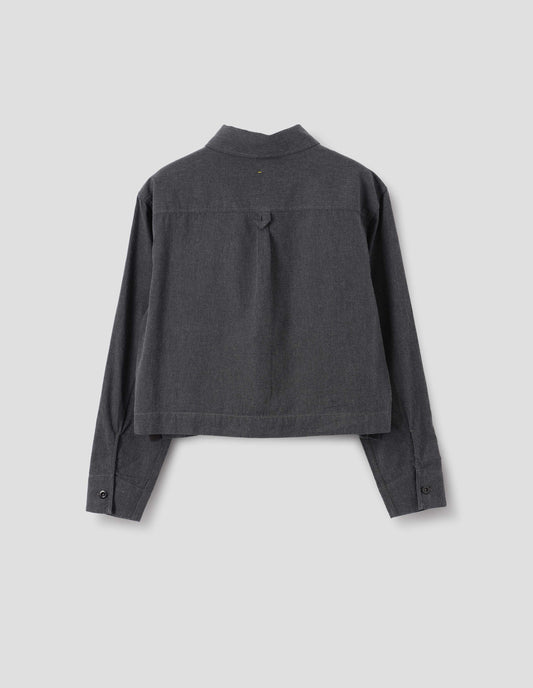 Dark grey cotton chambray shirt with grown-on cuffs, box pleat on back yoke and external hem loop detailing, front flat lay view.