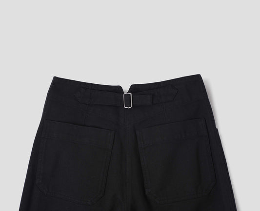Black cotton drill straight leg trousers with a stitch-through waistband, patch back pockets and cinch waist adjusters. Back flat lay view.