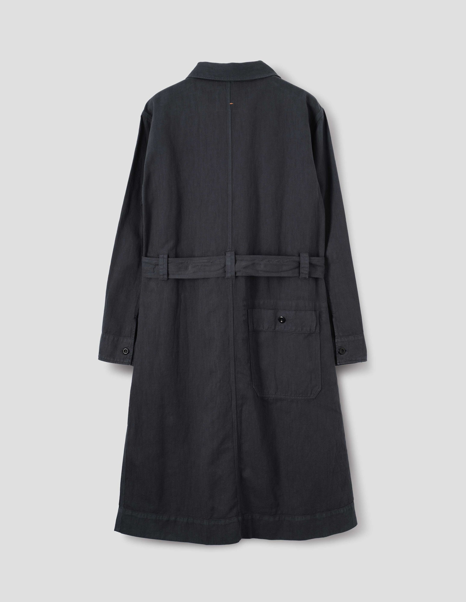 Dark navy overall dress with button-fastening split cuffs and button-through patch pocket at the back, finished with a removable belt. Back flat lay view.