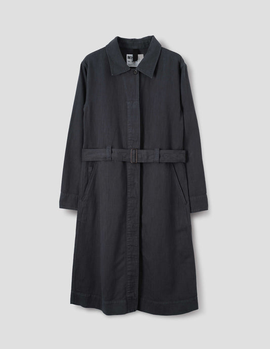 Dark navy overall dress with a fly front with button fastening, slanted pockets with a ticket pocket detail and finished with a removable belt with a metal slide adjuster. Front flat lay view.