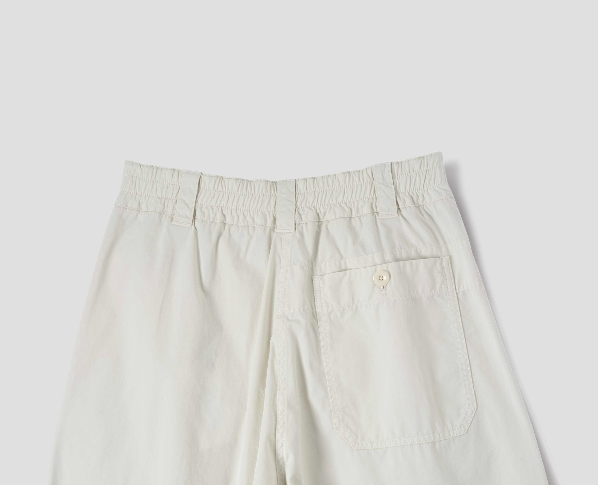 Off white cotton culottes, with elasticated waist and belt loops, a patch pocket with button, back flat lay view