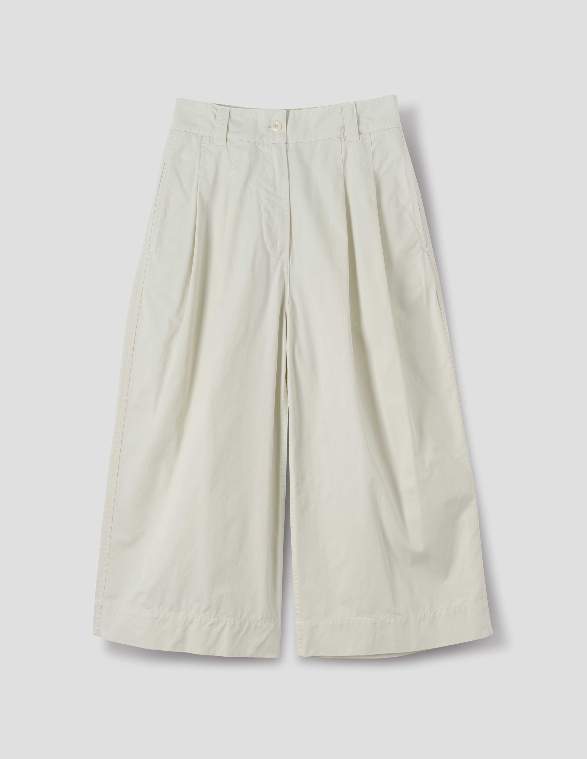 Off white cotton culottes, with front pleats, a white button and belt loops, front flat lay view.