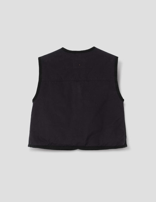 Black cotton twill sleeveless lightly padded liner with herringbone binding along edges and seam and back yoke with twin needle stitching, back flat lay view.