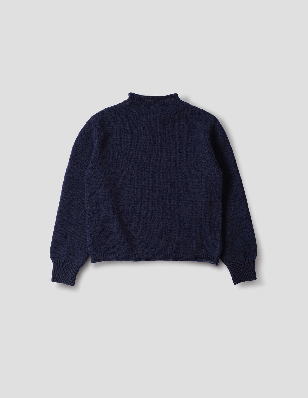 Dark blue midweight wool crew neck sweater with rib detailing and a rolled edge at the neck and hem, rib detailing on cuffs, back flat lay view.