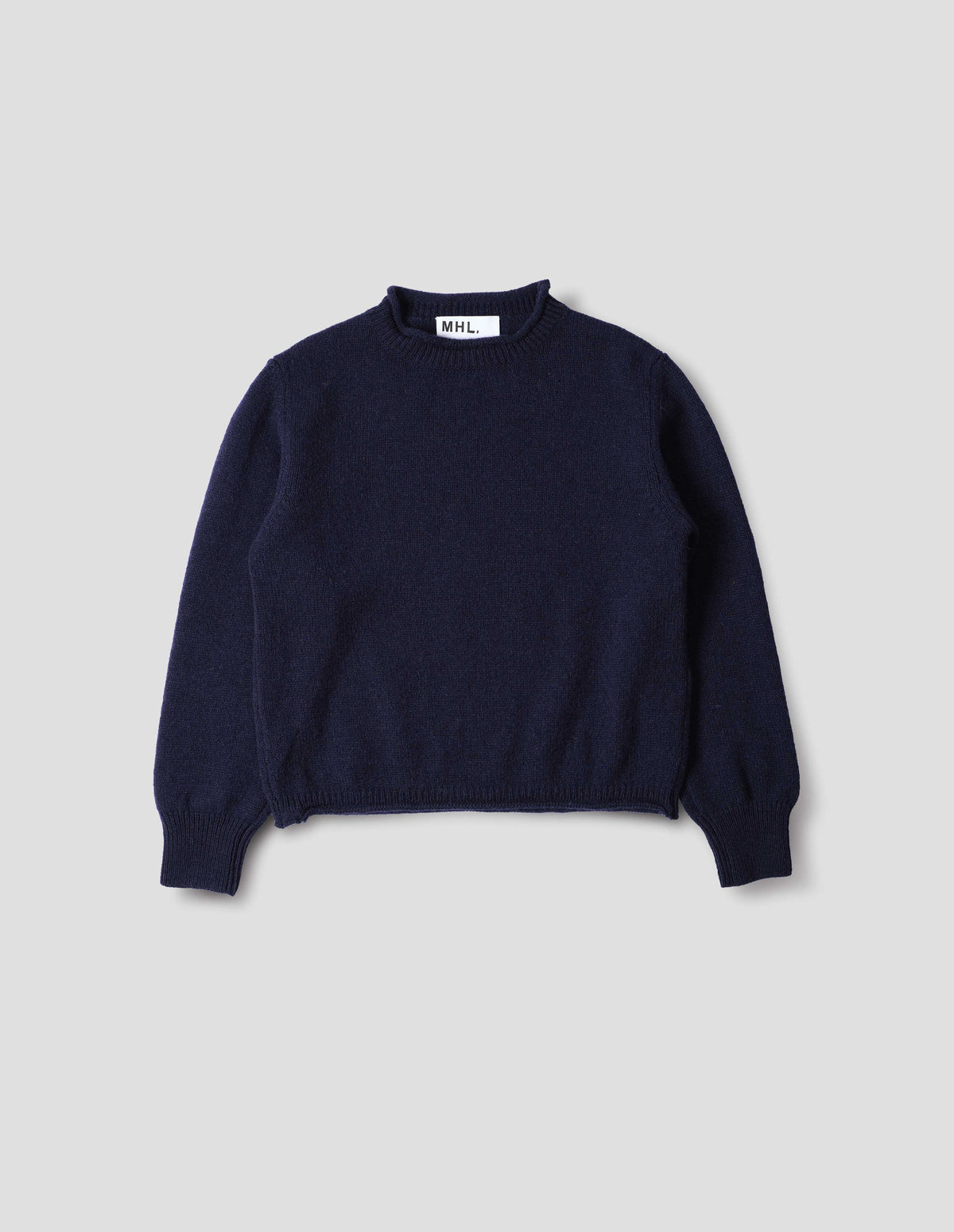 Dark blue midweight wool crew neck sweater with rib detailing and a rolled edge at the neck and hem, rib detailing on cuffs, front flat lay view.