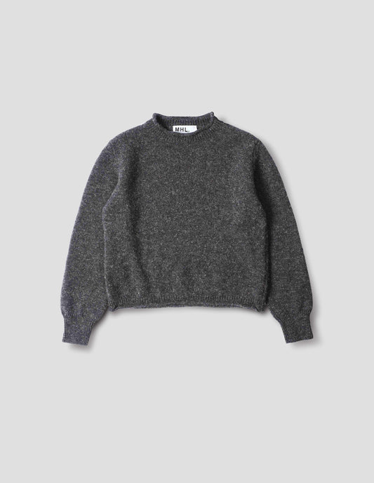 Dark grey wool crew neck jumper with a rolled edge on neck and hem, rib detailing on cuffs. Front flat lay view. 