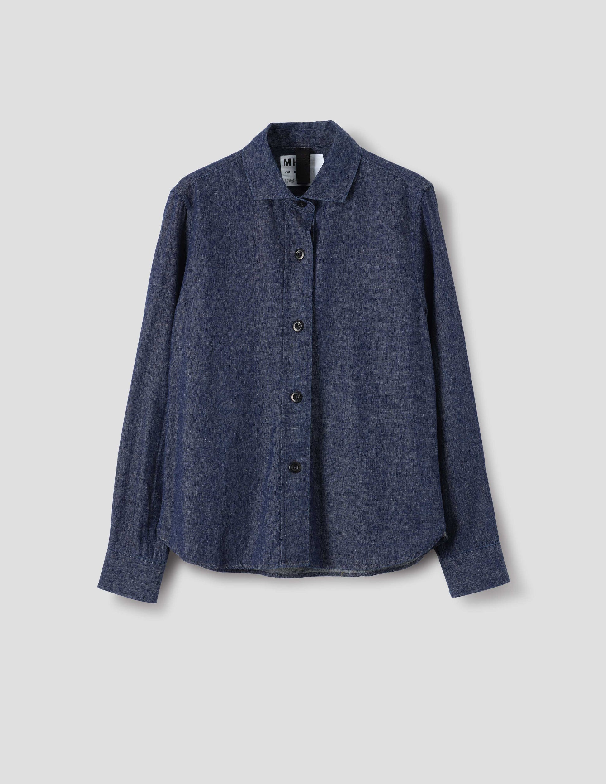 Blue cotton linen shirt, with rounded hem and dark buttons, front flat lay view.