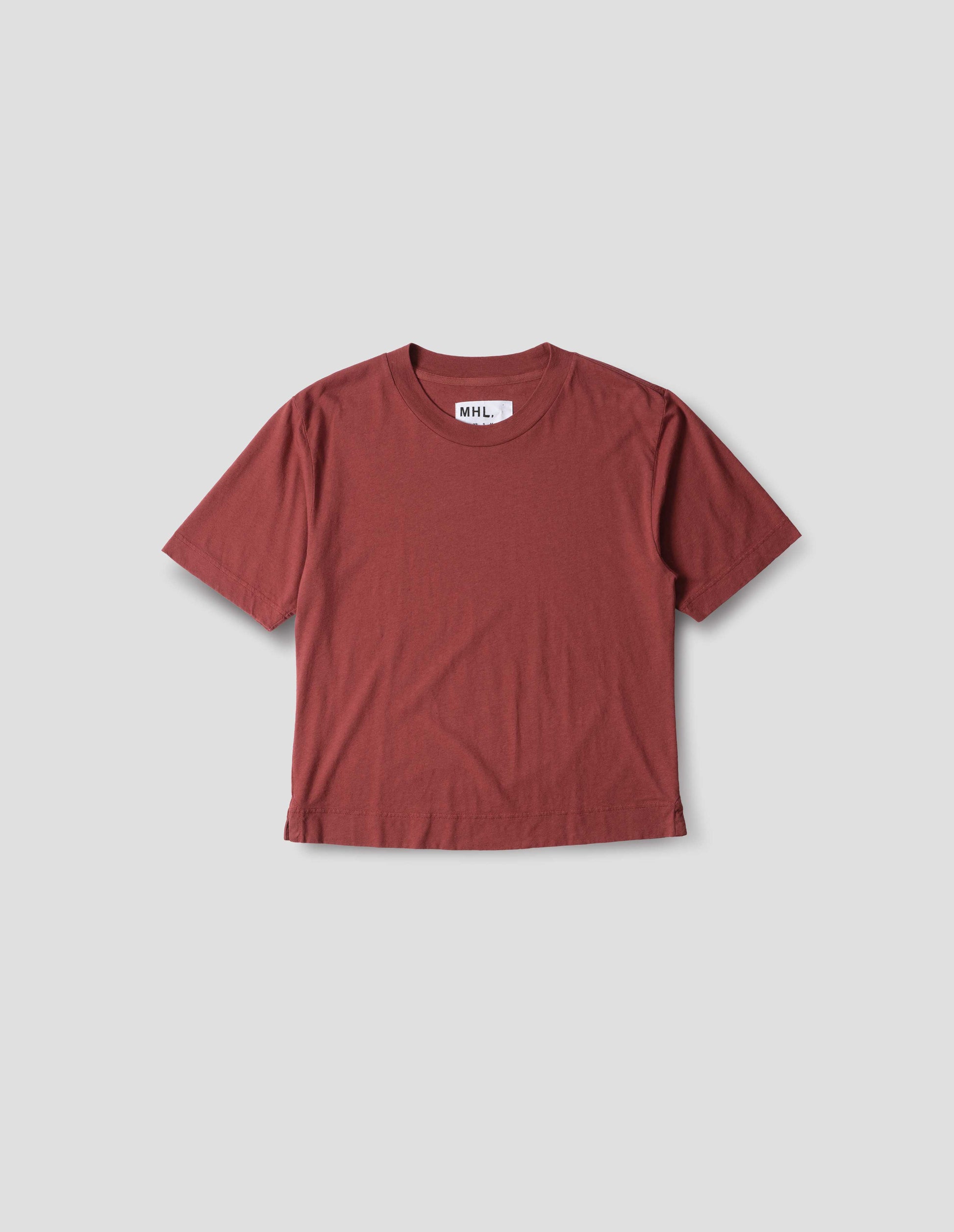 Red boxy cotton linen short sleeve t shirt with herringbone tape detailing inside the neck and vent split hem. Front flat lay view.