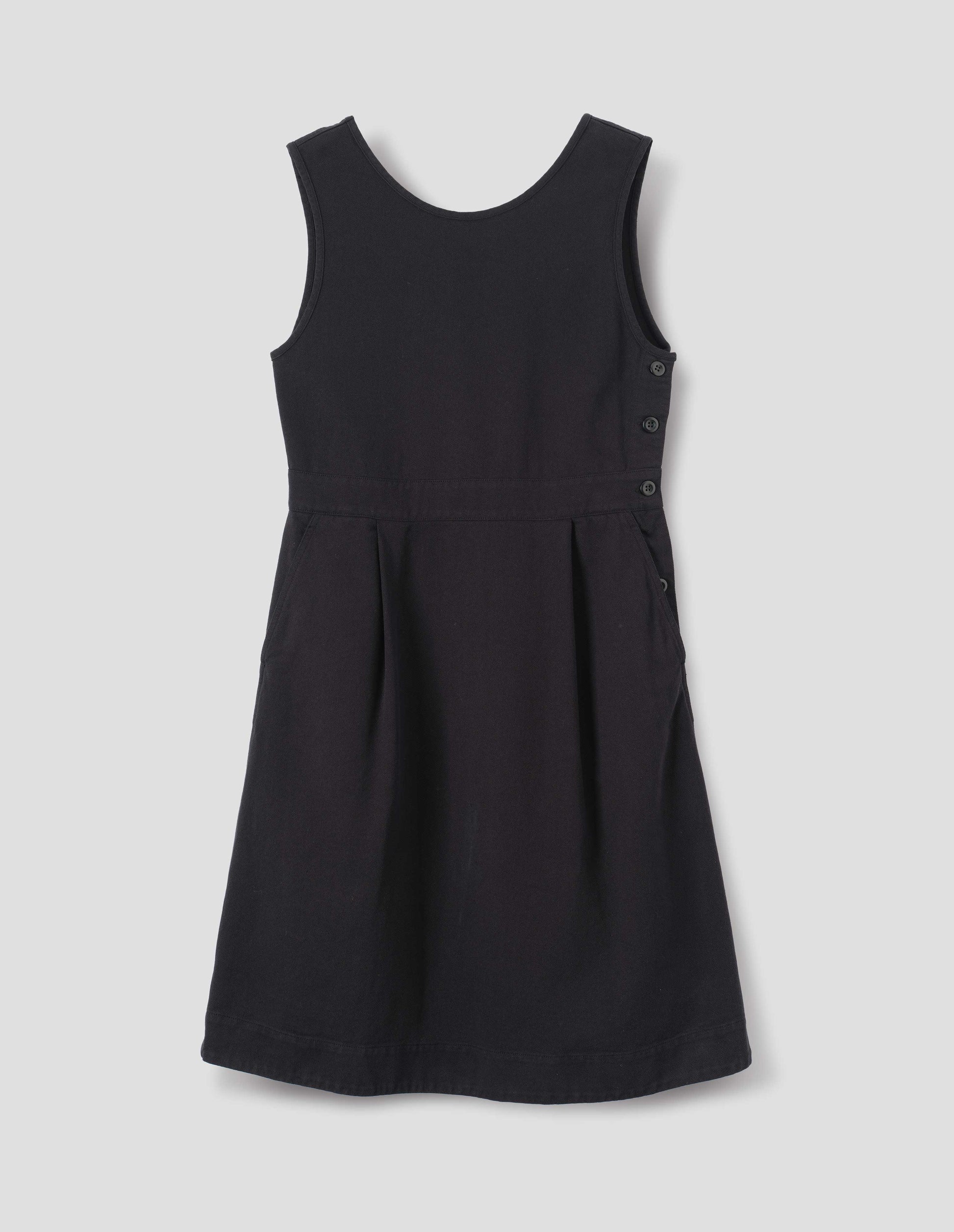 Black cotton dress, with side button fastening two pleats and slanted pockets, front flat lay view.