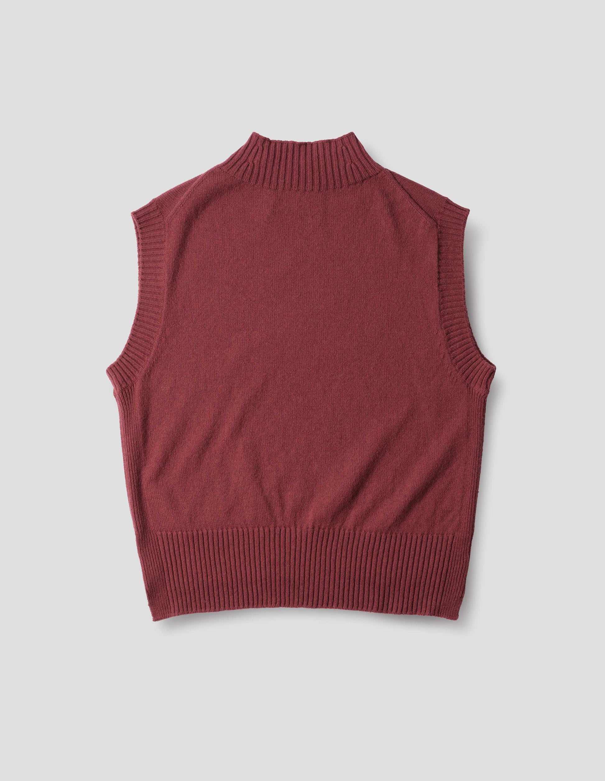 Reddish wool cotton slipover with a high rib neck, rib armholes and hem, back flat lay view.