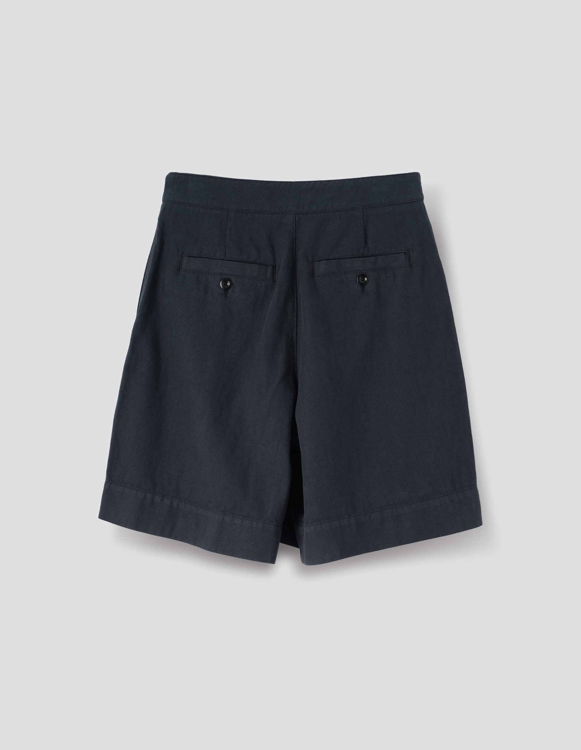 Dark blue cotton shorts, with  two button-fastening welt pockets, back flat lay view.