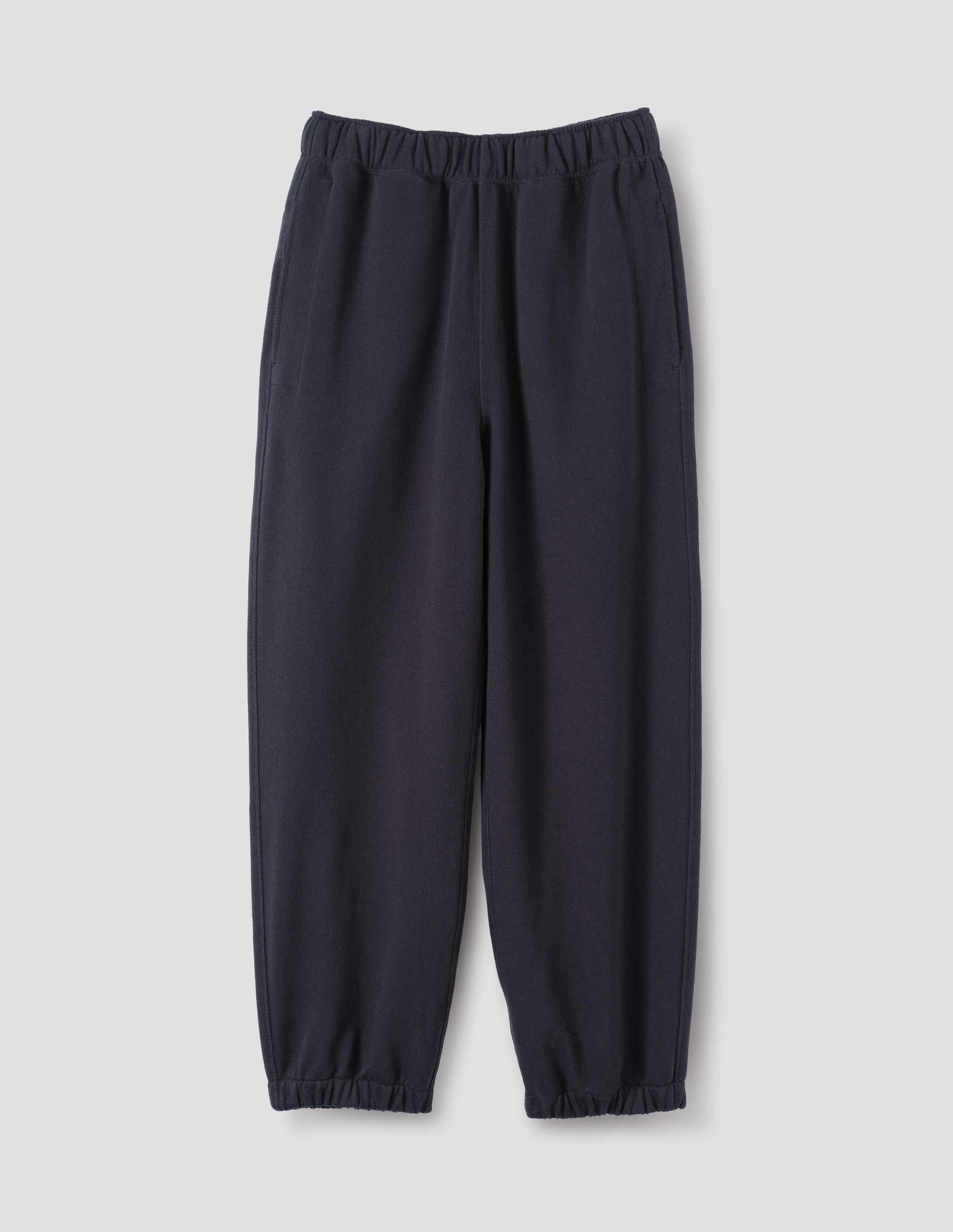 Dark navy lightweight jogger style trousers with side pockets and elasticated waistband and hem, front flat lay view.