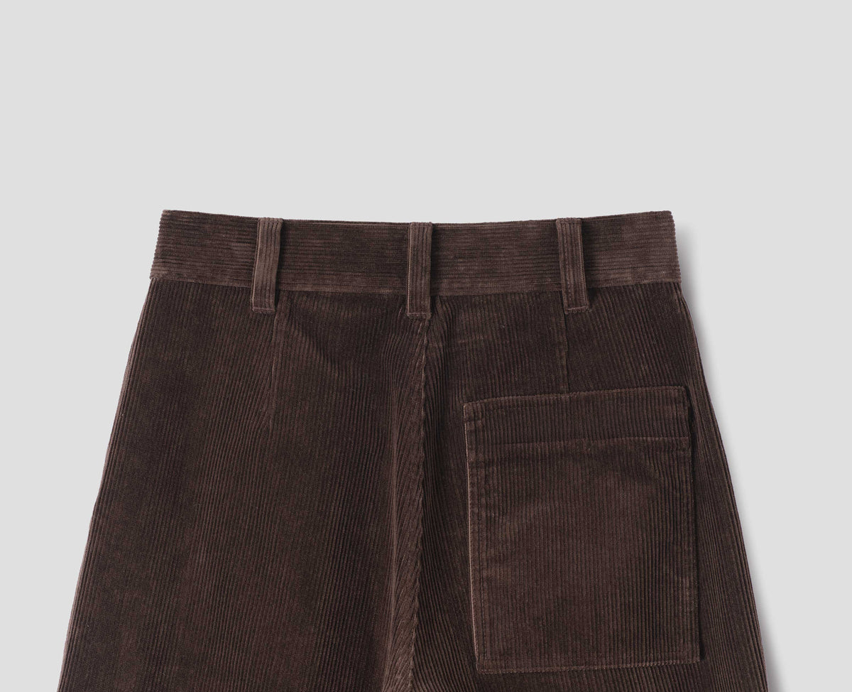 Brown corduroy trousers with a back patch pocket and shaping darts, back flat lay view.