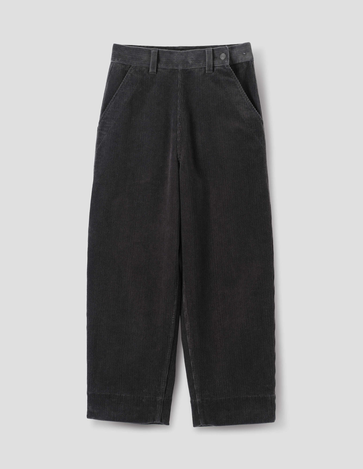Dark grey cotton corduroy trousers, with offset button fastening waistband, flat front side opening, slanted pocket and deep hem. Front flat lay view.